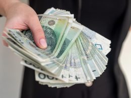 Młoda kobieta pokazuje polskie pieniądze z bliska